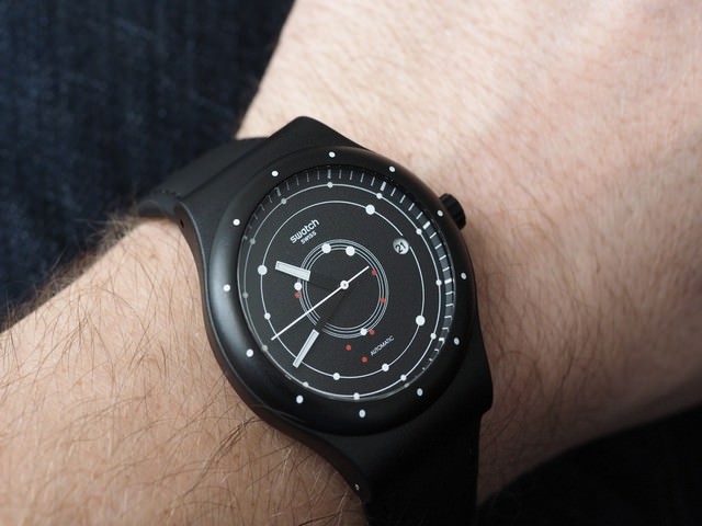 Швейцарские часы Swatch. изображенные на мужской руке